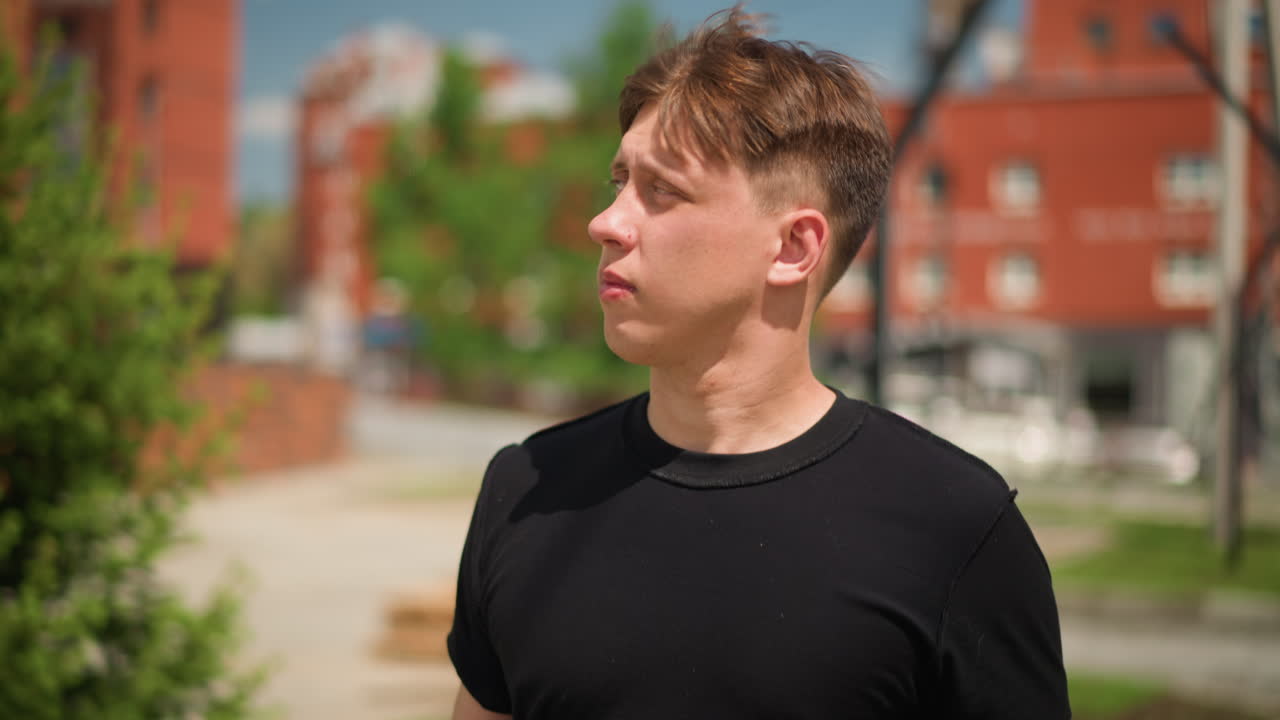 밝고 희망찬 십 대가 건설 현장 근처에서 밝은 미소로 따뜻함을 보여주고 있어요. 자신감 넘치고 쾌활한 젊은이가 건물 건설 구역에서 희망찬 표정으로 서 있습니다.