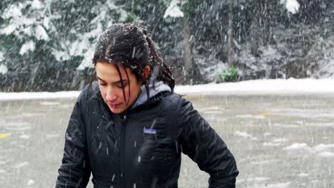 beautiful woman exercising during snowfall