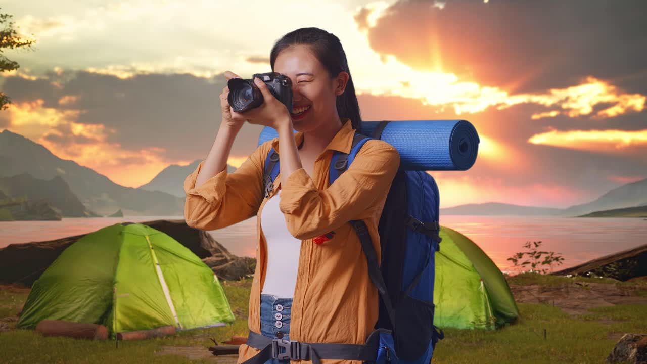 Woman taking photos during a camping trip at sunset