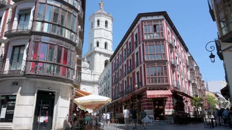 low-angle view of a sunny cascajeras street with pedestrians and valladolid cathedral in the background, valladolid, spain.