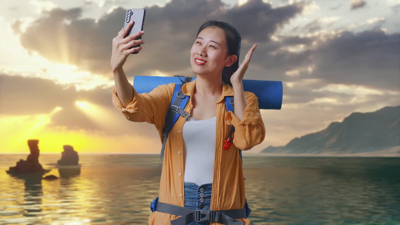 Gün batımında sahilde selfie çeken dağcılık sırt çantalı Asyalı kadın yürüyüşçü