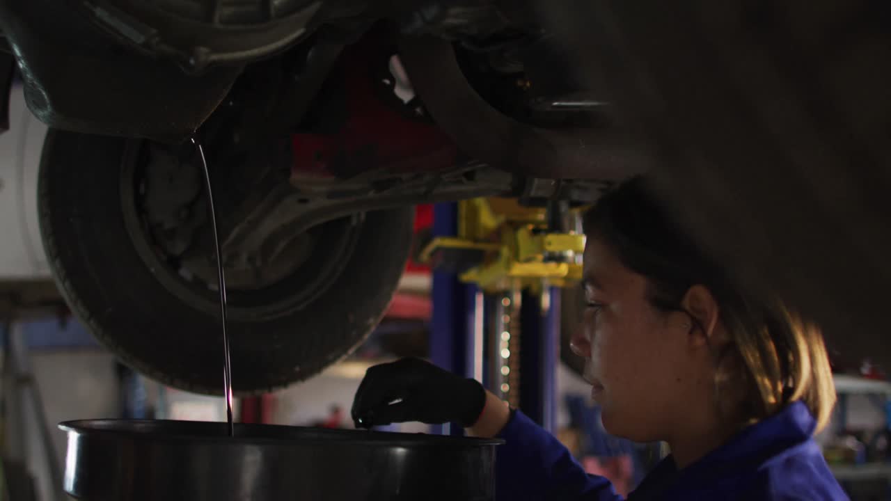 mecánica cambiando el aceite del coche en una estación de servicio de coches