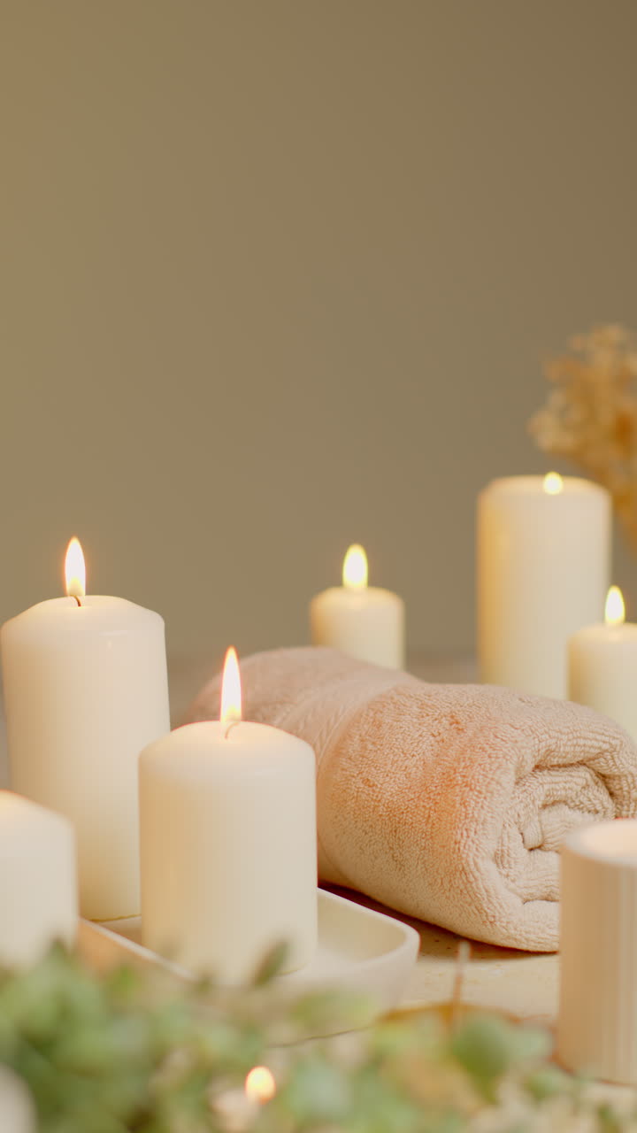 vida vertical de velas encendidas con hierbas secas, incienso y toallas suaves como parte de la relajante decoración del día de spa 4
