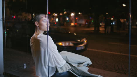 woman sitting at night bus stop