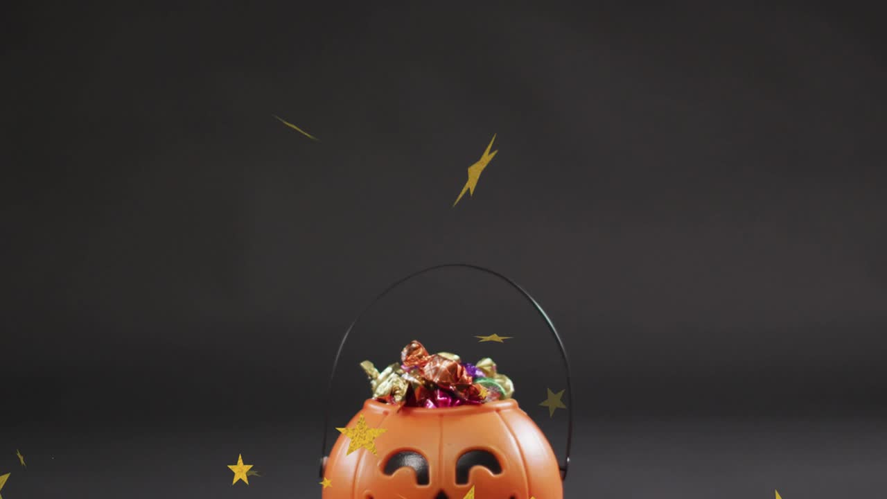 Gold stars drifting onto pumpkin candy bucket swirling over candy and handle, creating festive look