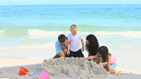 joyful family building a sand castle