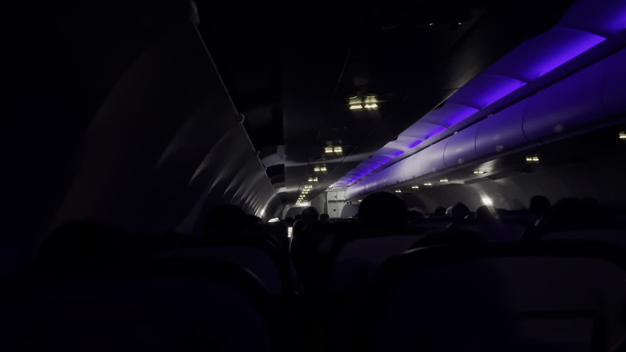 Vista di persone sedute su un aereo di notte