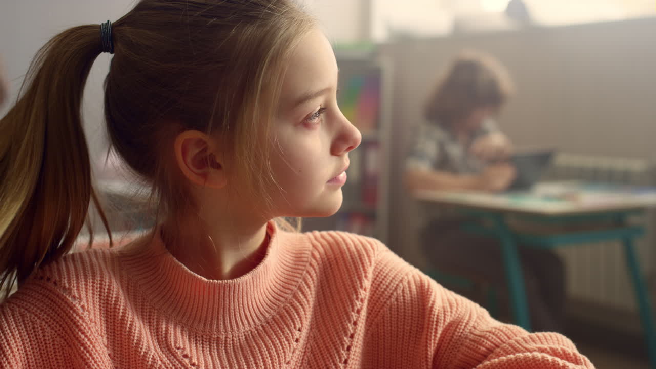 школьница смотрит на экран цифрового планшета. студент учится с блокнотом