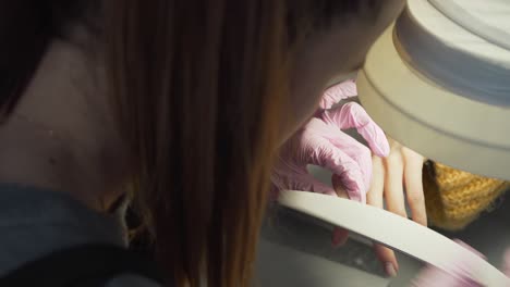 the manicure expert fixing nails of the girl with tender hands using nail file