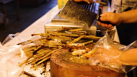 chef chops grilled chicken at floating market stall