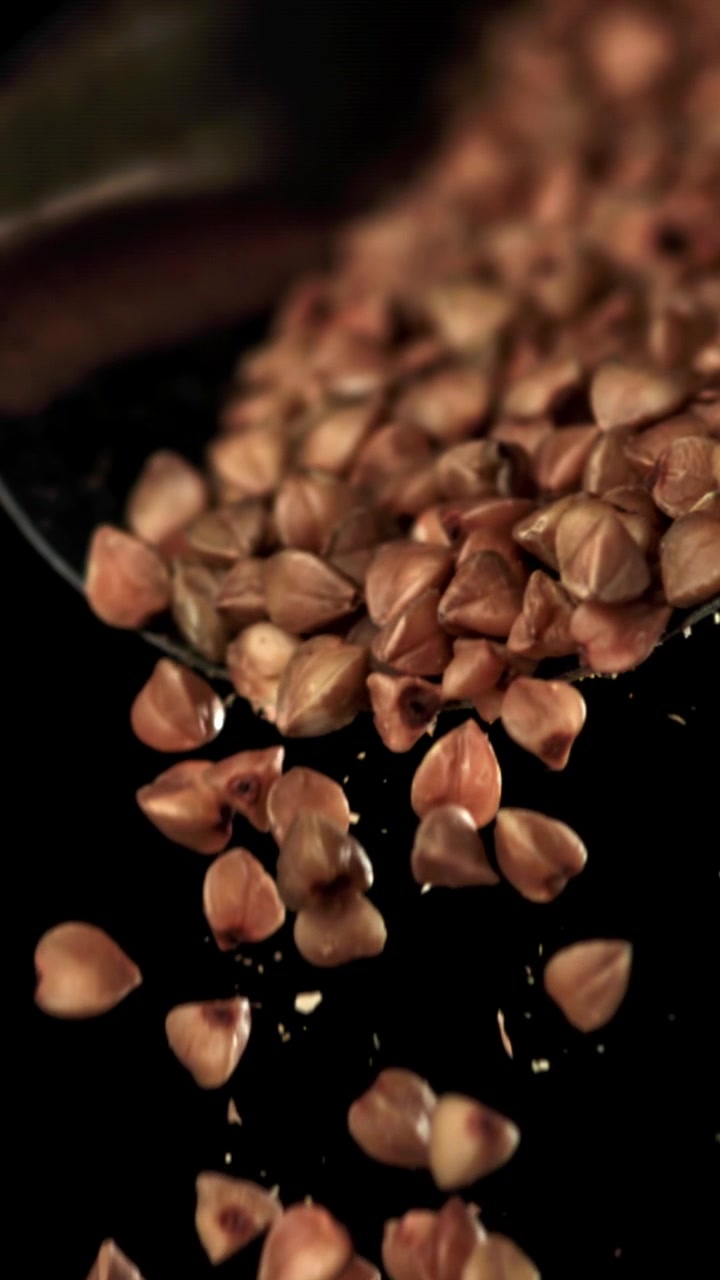 Buckwheat Grains Falling in Super Slow Motion on Black Background