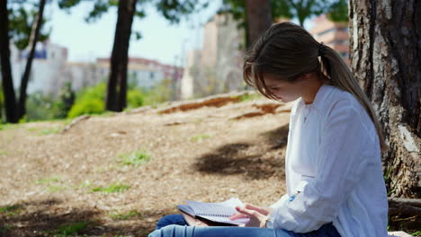 young woman studying outdoors in a park