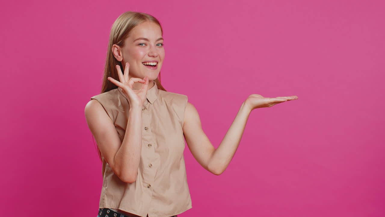 mujer joven mostrando los pulgares hacia arriba y apuntando a la derecha en el espacio en blanco lugar para su logotipo de publicidad