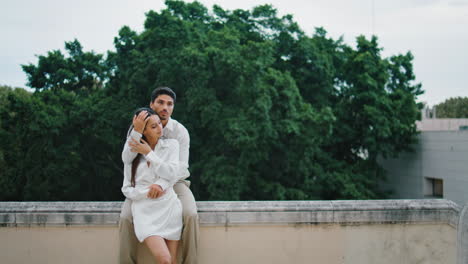 tender lovers cuddling at observation platform vertical. man caressing woman