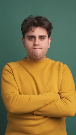 sad and angry man standing with arms crossed looking around