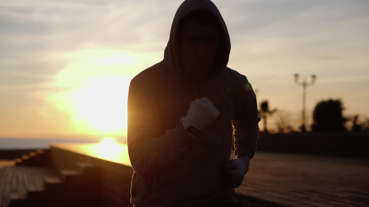 Silhouette di un pugile che si prepara per un allenamento al tramonto