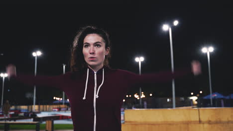 sportive curly girl stretching and rotating arms in the park at night 3