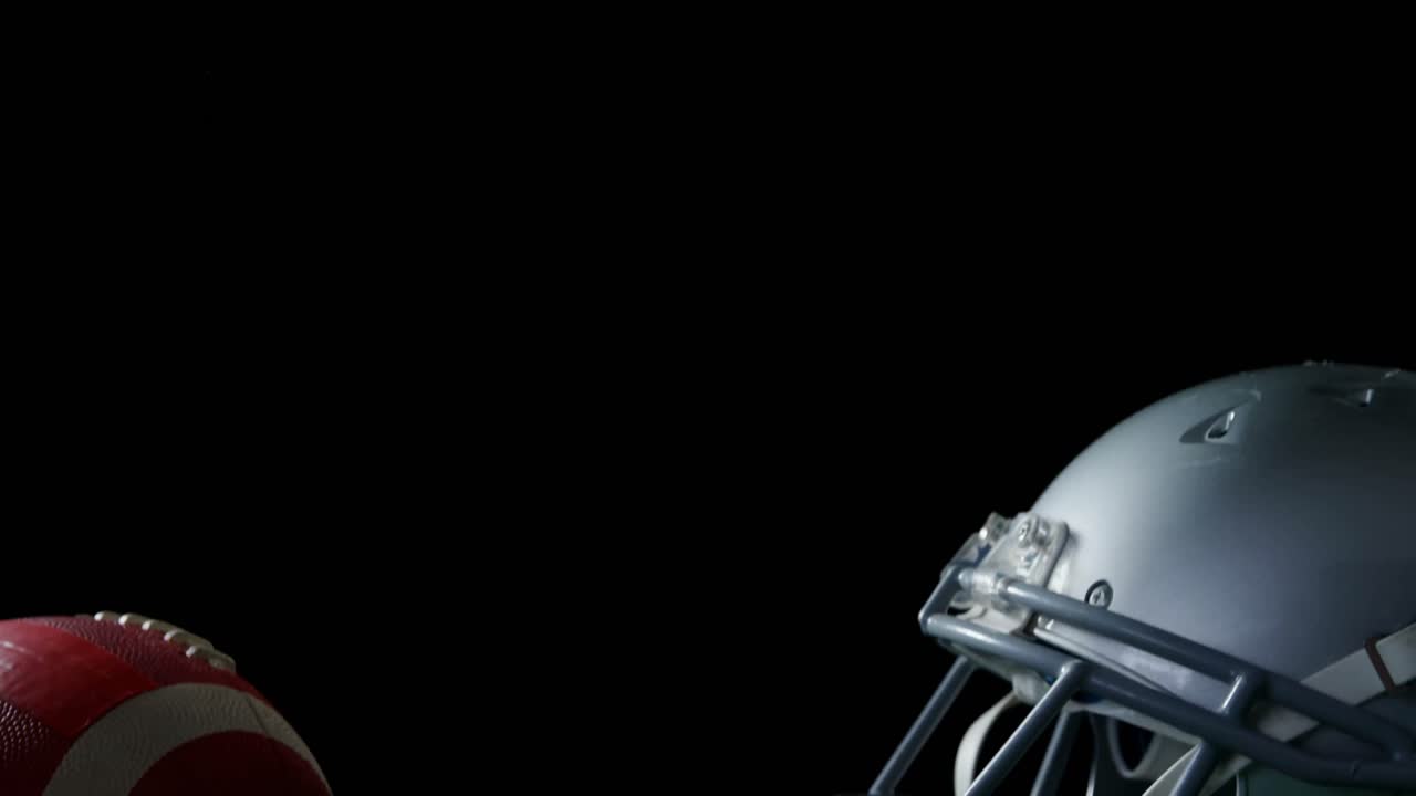 Casco e pallone da football americano su campo in erba sintetica 4k