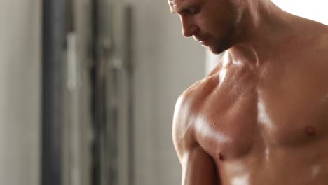 fit man lifting heavy black dumbbell