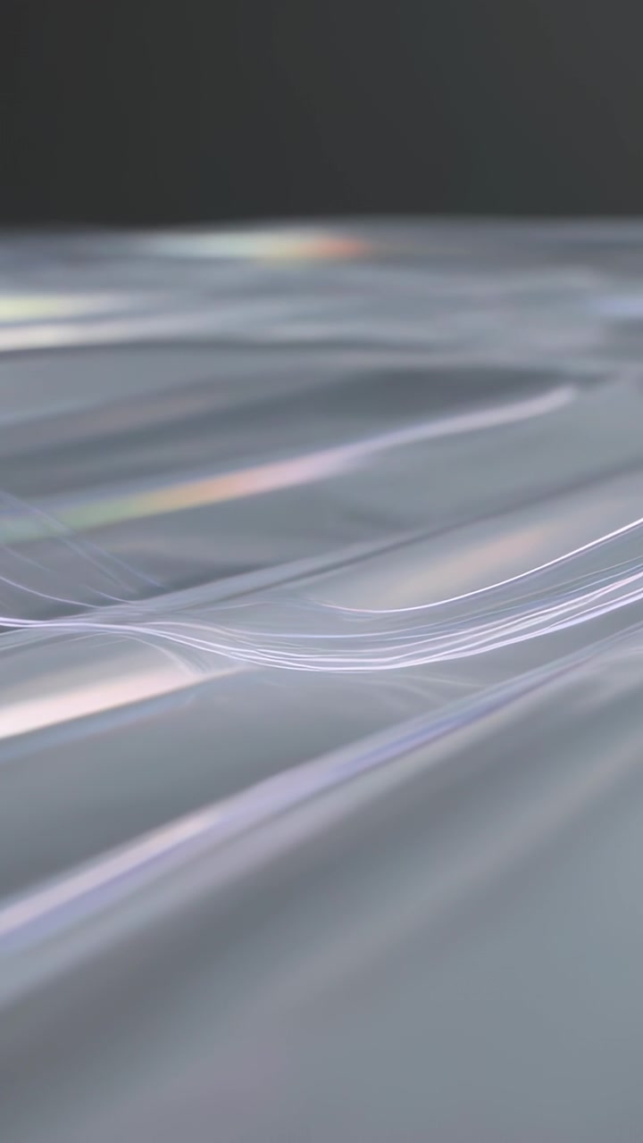 Vertical video: Playback starting ribbons swaying over plane in studio, forming iridescence