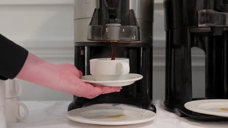 café vertiendo en una taza de una máquina de café en una tienda