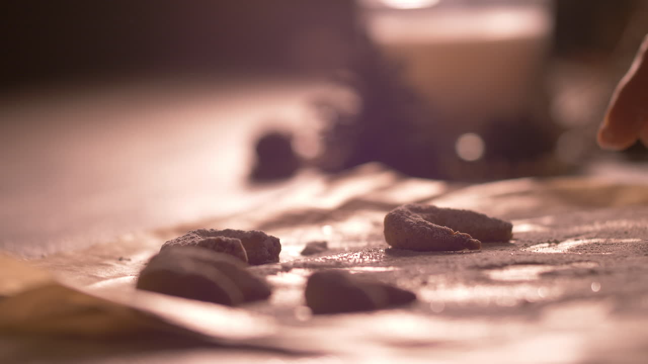 Mother collects the cookies from the baking paper and picks them up , close up