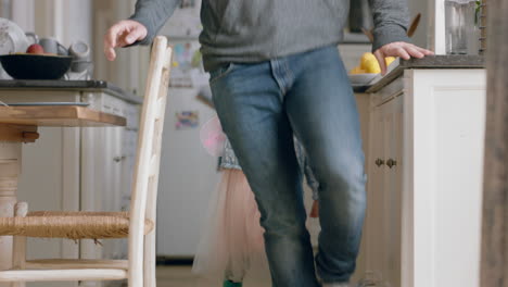 Niña-Feliz-Persiguiendo-A-Su-Padre-En-La-Cocina-Jugando-Con-Un-Lindo-Disfraz-De-Hada-Disfrutando-De-Diversión-En-Casa-Con-Papá