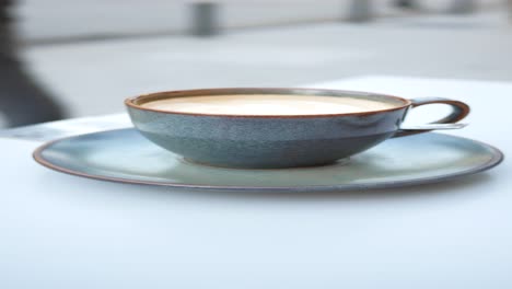 a cup of coffee on a table at an outdoor cafe