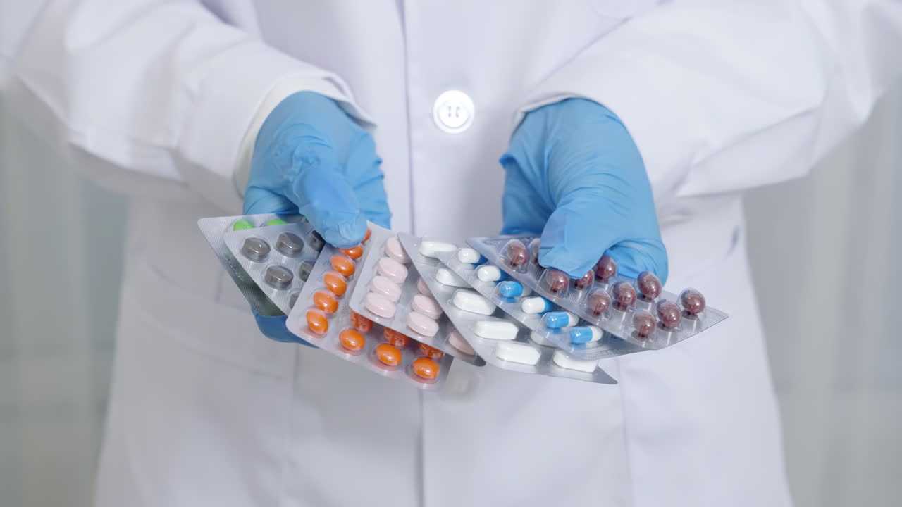Doctor's hands in protective gloves spreading out various pharmaceutical pills, capsules and tablets for health, wellness and cure treatment therapy drugs concept healthcare and wellness
