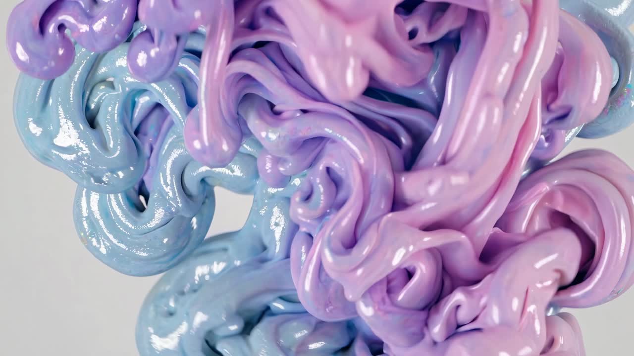 Döndürmeli, soyut bir görünüm sunan, parlak dokulu, pastel renkli slime’ın yukarıdan aşağıya doğru çekilmiş video görüntüsü