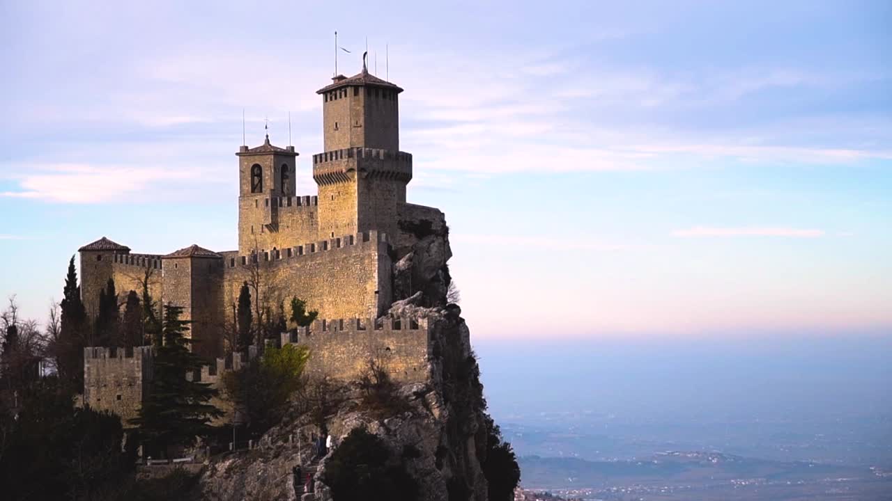 vista panorámica de la antigua fortaleza medieval de san marino en una puesta de sol de invierno con pocas nubes