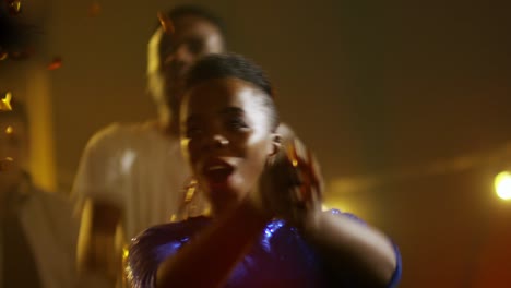 mujer bailando y arrojando confeti en la fiesta