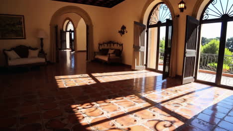spacious room with terracotta tiles and archways leading to balcony