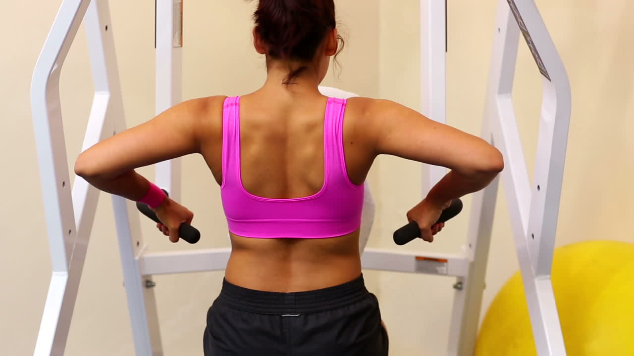 una mujer tonificada entrenando los músculos de sus brazos.