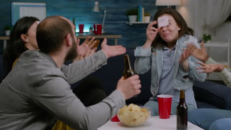 multiethnic group of people drinking beer playing board game