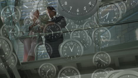 clocks animation over business people discussing in modern office building