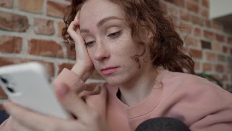 Close-up-video-of-young-sad-caucasian-woman-using-mobile-phone