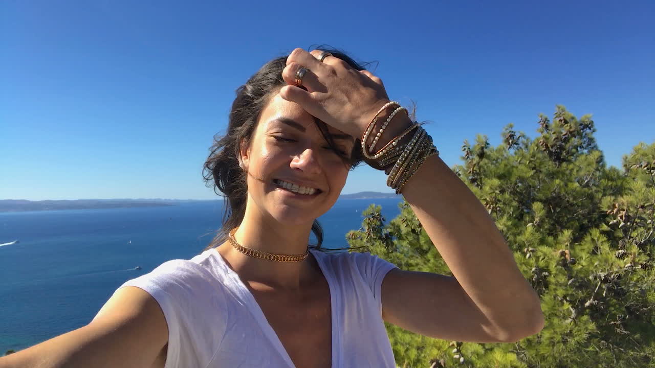 hermosa y sonriente joven modelo tomando selfie en split, dalmacia, croacia desde la cima de la colina de marjan