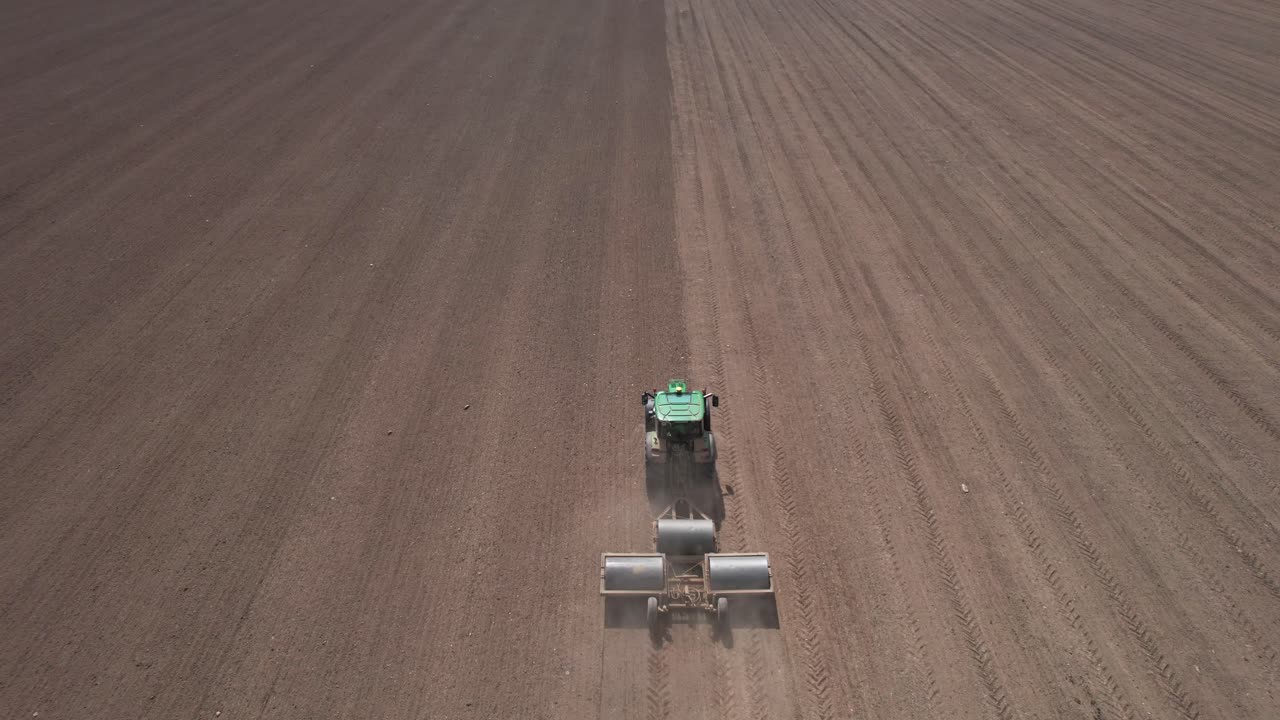 vista aérea de drones del tractor con tres rodillos pesados aplanando la tierra, subiendo