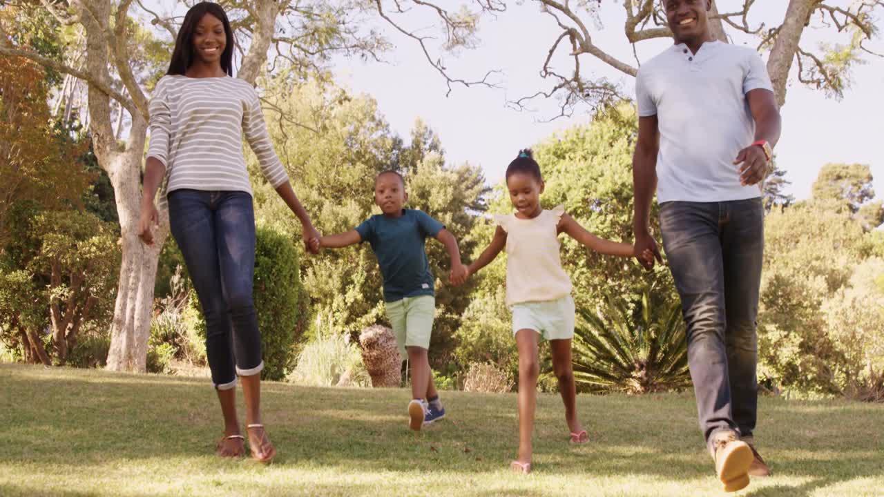 vista de ángulo bajo de una familia feliz tomados de la mano y caminando