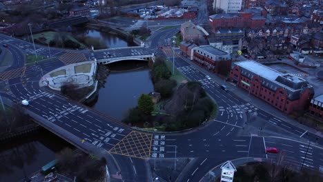 aerial view looking down city centre canal roundabout infrastructure suburban streets traffic at daybreak push in right