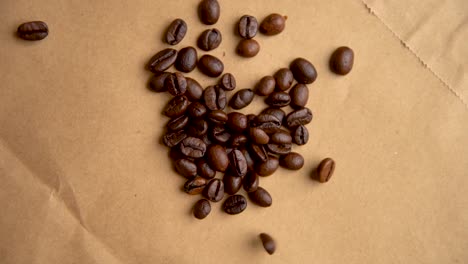 coffee beans drop from above on old paper slow motion