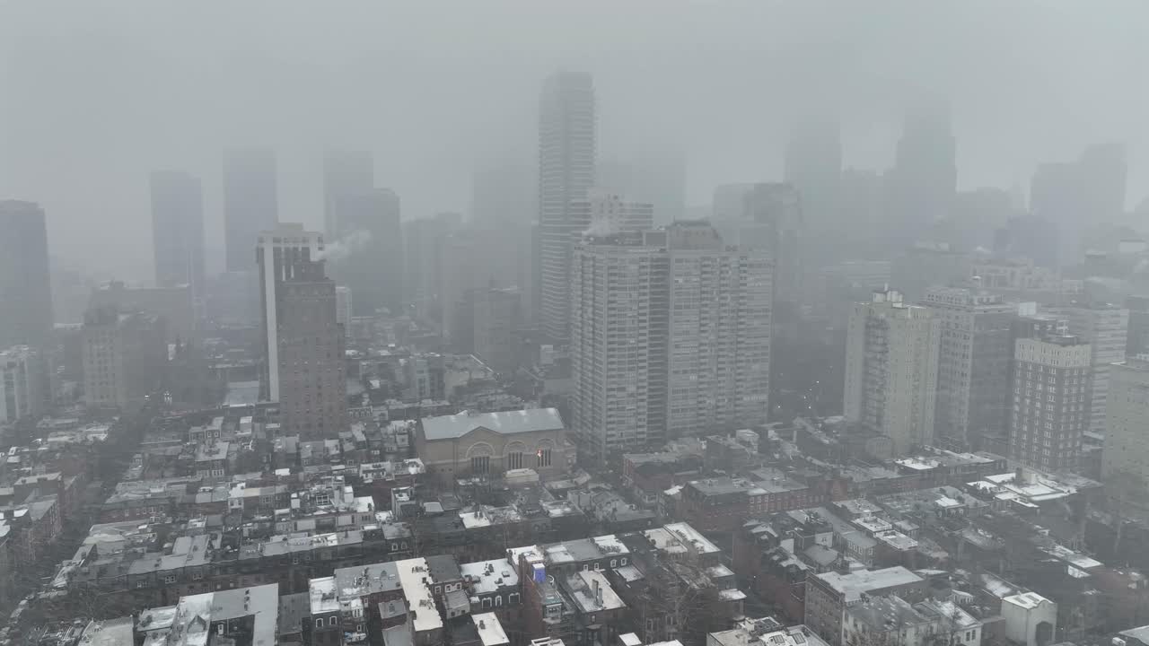 冬季暴風雪期間費城鬧市區的鳥瞰圖。摩天大樓在濃霧和降雪中隱約可見。美國城市天際線籠罩著灰暗、神秘的城市氛圍。廣角鏡頭。