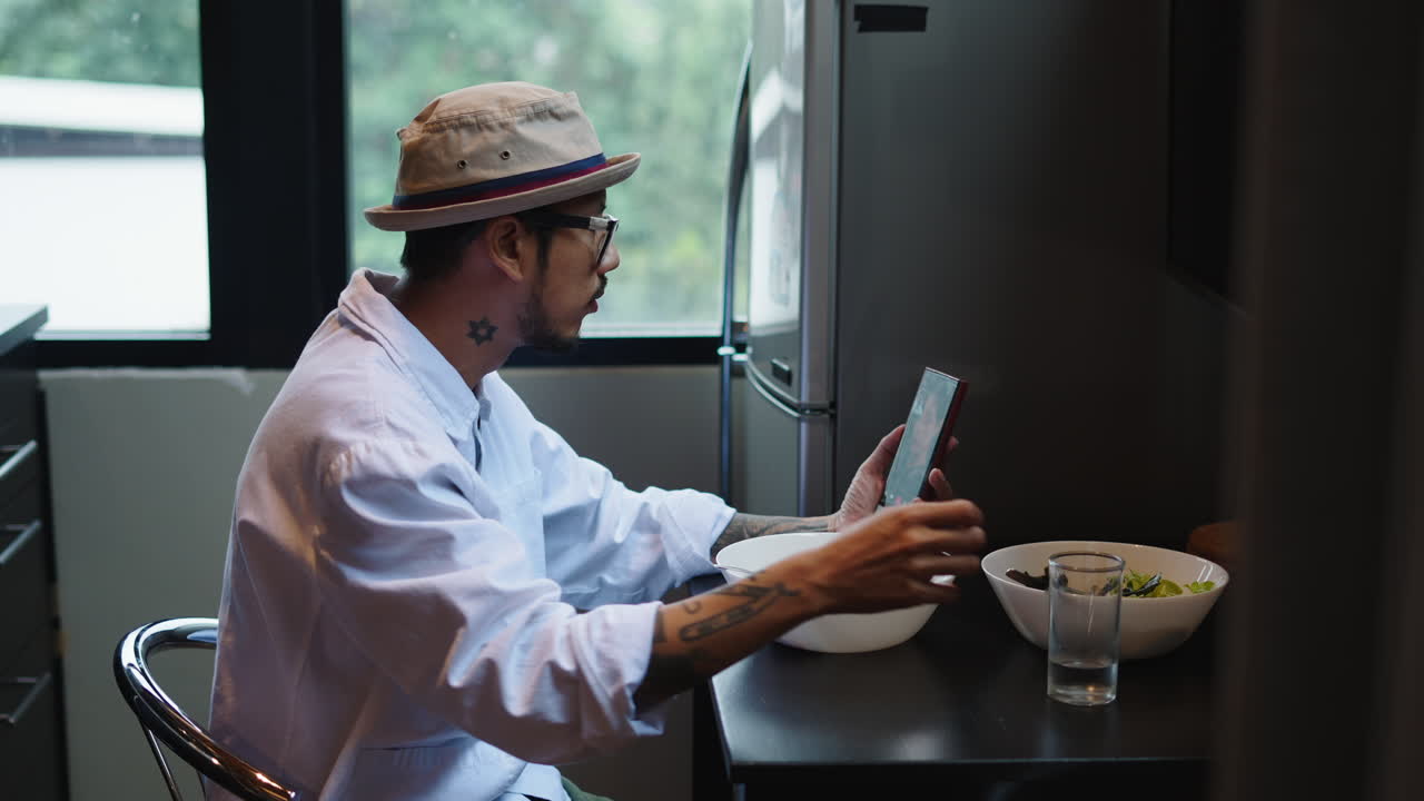 Man eating salad while on a video call