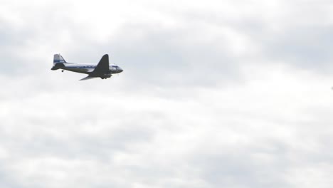 Silver-and-Blue-Douglas-DC3-performs-at-Baltic-International-Airshow,-carrying-out-flypast,-view-from-the-ground,-handheld-4k-shot