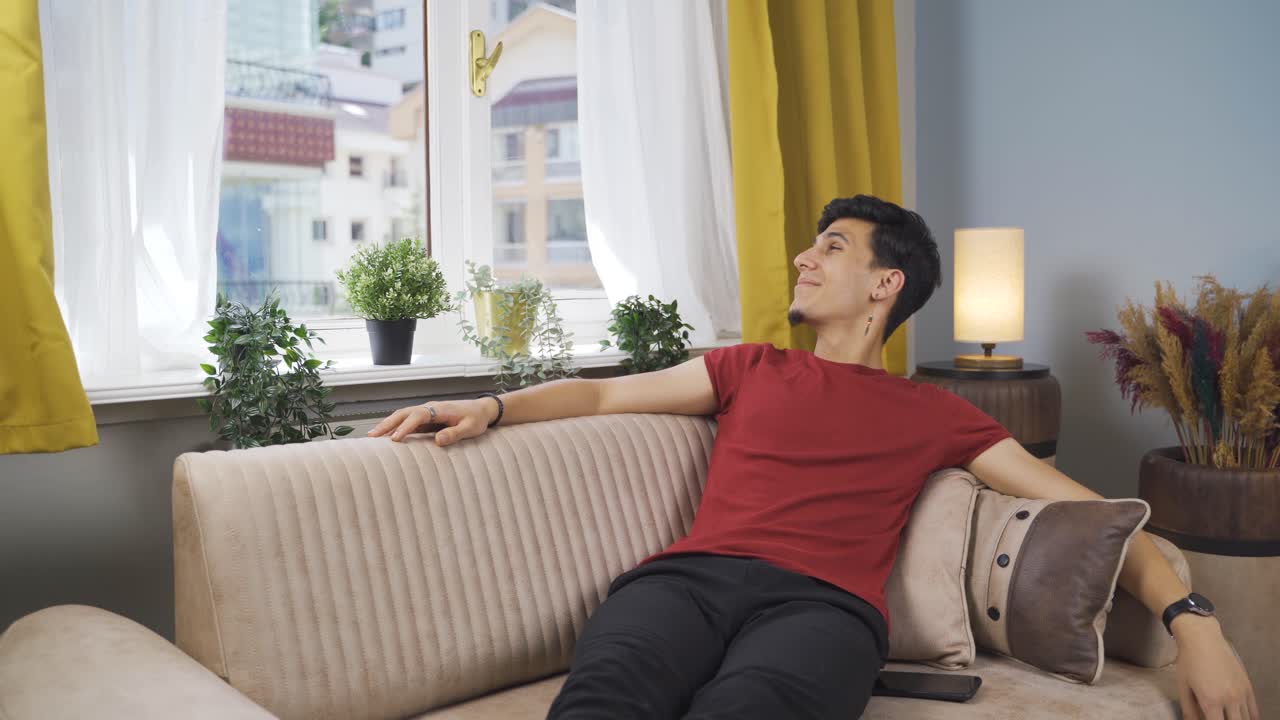 소파에 누워 있는 행복한 남자. 그는 휴식을 취하고 있다.