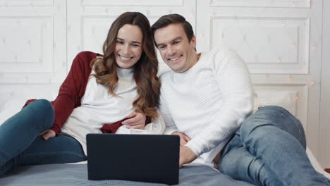 Happy-family-laughing-in-front-of-laptop-screen-in-living-room.