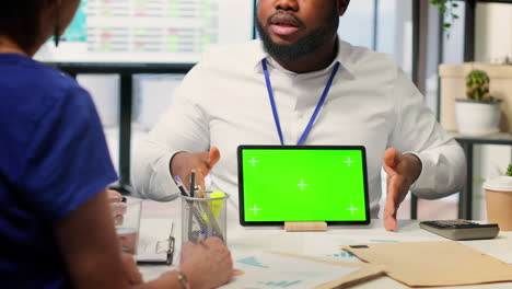 Financial-advisor-works-with-a-green-screen-at-table-with-his-senior-clients