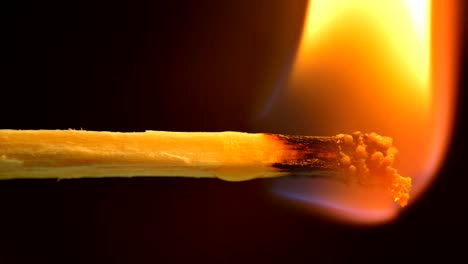 fósforo ardiente y llama. fósforo de seguridad en primer plano sobre un fondo negro.