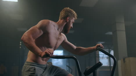 Joven-Usando-Bicicleta-Estática-En-El-Gimnasio.-Hombre-De-Fitness-Usando-Bicicleta-De-Aire-Para-Hacer-Ejercicio-Cardiovascular-En-El-Gimnasio.-Esfuerzo-Del-Equipo.